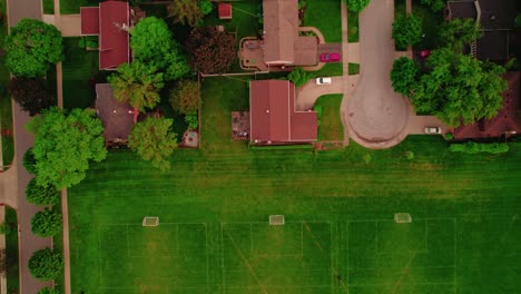 vista aérea de arriba hacia abajo de casas en los suburbios de chicago adyacentes a múltiples campos de fútbol