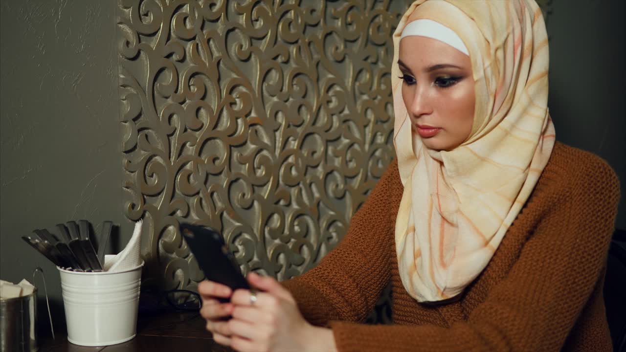 joven usando un teléfono inteligente en un café