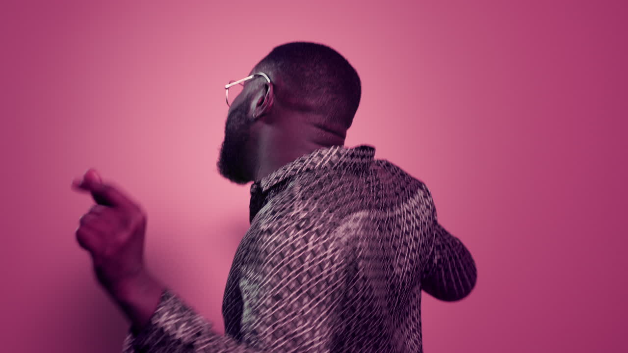 Afro guy turning around in studio. Delighted male person dancing indoors