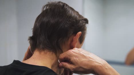 cierre en cámara lenta del anciano poniendo su máscara facial con fondo blanco