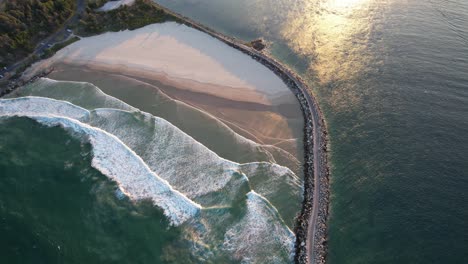 aerial view of turners beach during sunset - clarence river and yamba breakwater in nsw, australia