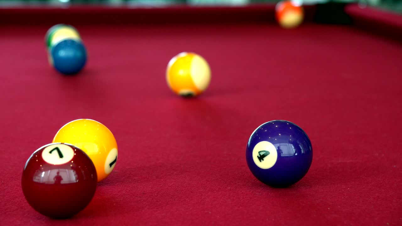 Playing the pool-billiard game on red baize table. This is sports