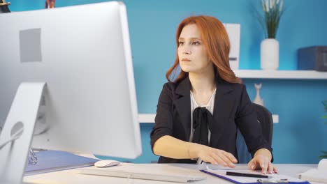 mujer de negocios enfocada trabajando seriamente en la computadora en la oficina.