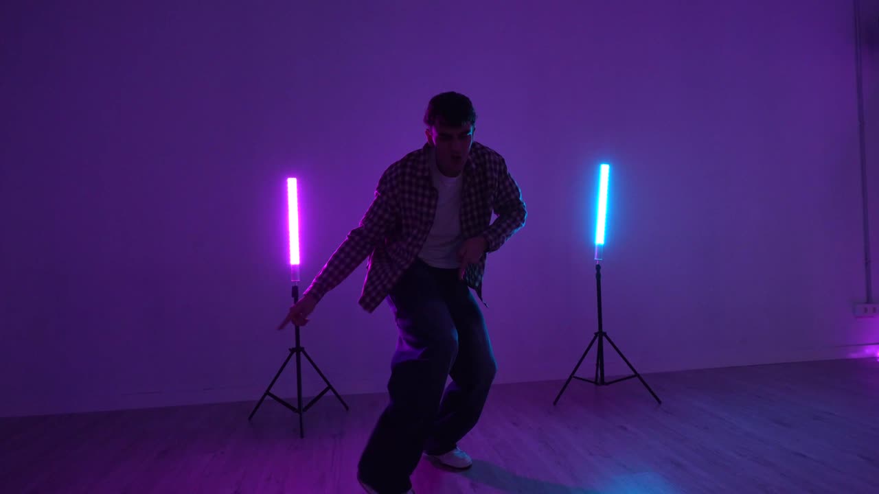 Uomo che balla in studio con luci al neon