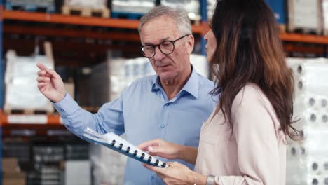 mature woman and man analyzing documents in the warehouse