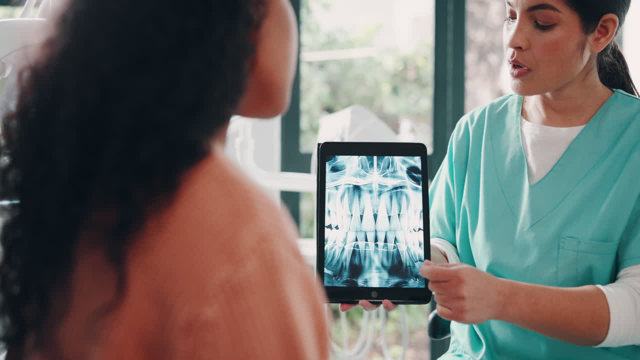 dentista mostrando una radiografía dental en una tableta a un paciente