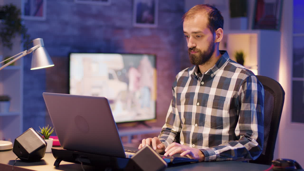 Man working on a laptop in an office at night