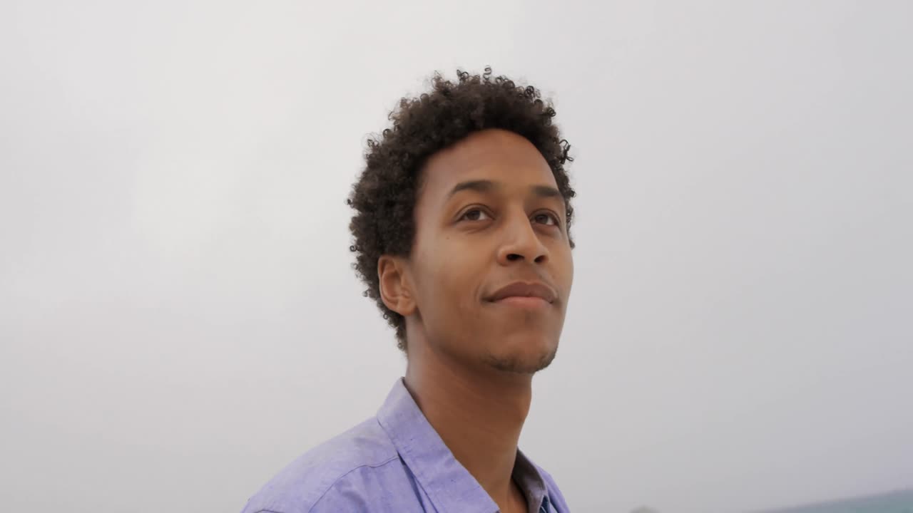 Front view of African American man standing on the beach 4k