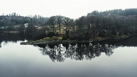 peaceful lake with island and trees reflecting on water, serene mood