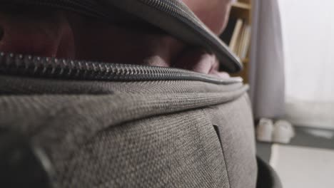 close up of person at home zipping up suitcase ready for summer holiday