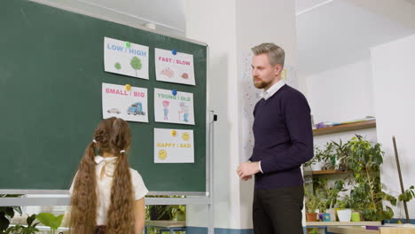 Teacher-And-Student-In-Front-Of-Blackboard-In-English-Classroom-1