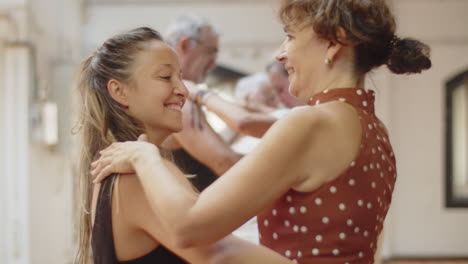 Side-view-of-woman-rehearsing-waltz-with-female-dance-teacher