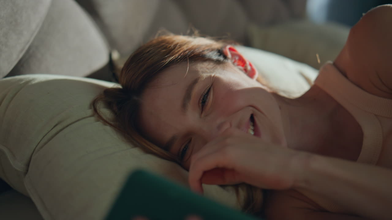 Morning girl looking cellphone with smile lying bed pillows closeup. Happy woman