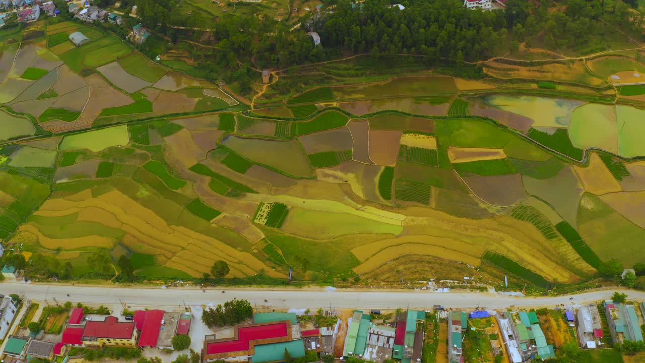 toma aérea de arriba hacia abajo de empanadas de arroz a lo largo de un río que conduce a la ciudad de dong van, en el geoparque de la meseta de karst de dong van