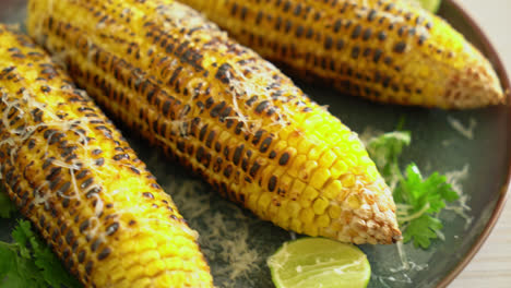 barbecue and grilled corn with cheese and lime on plate