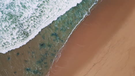 grey sea water covering beach slow motion. stormy ocean waves aerial top view