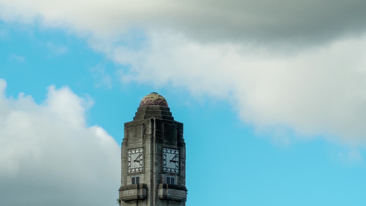 torre del reloj marcando el tiempo con nubes moviéndose en el cielo azul, lapso de tiempo