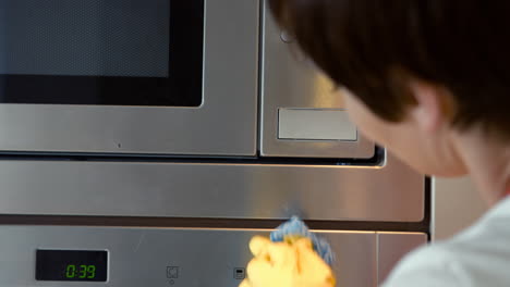 woman cleaning the microwave