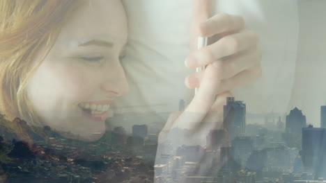 animation of cityscape over smiling caucasian businesswoman using smartphone