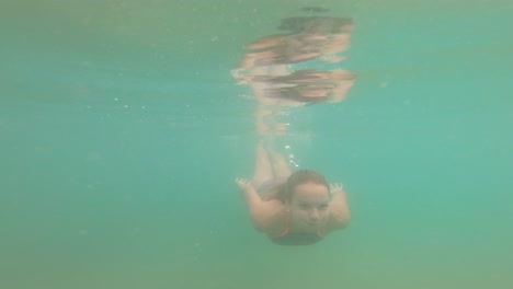 Teenage-girl-having-fun-on-holidays-and-dives-in-green-waters