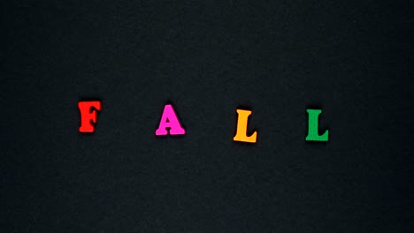 word "fall" formed of wooden multicolored letters. colorful words loop.