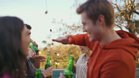 multiethnic group gathering rooftop party closeup. carefree people drinking beer