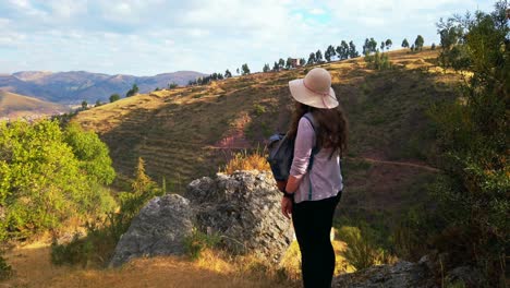 woman traveler with peruvian hat admires scenic cusco valleys near rumiwasi ruins, peru