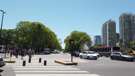 panning view at palermo neighborhood, pedestrian cross and traffic of santa fé avenue in summer daylight