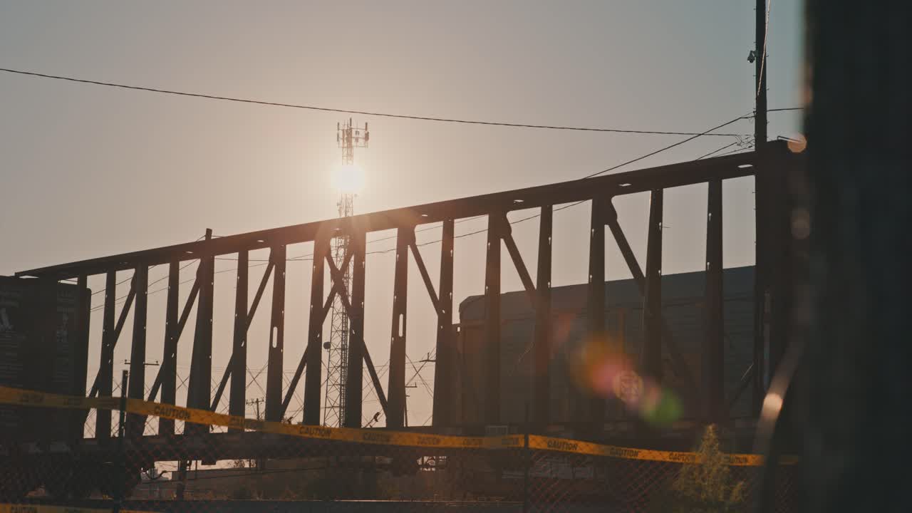 Freight Train Leaving Train Yard with Empty Cargo Carts in Slow Motion During Golden Hour with Sun Flares Cinematic