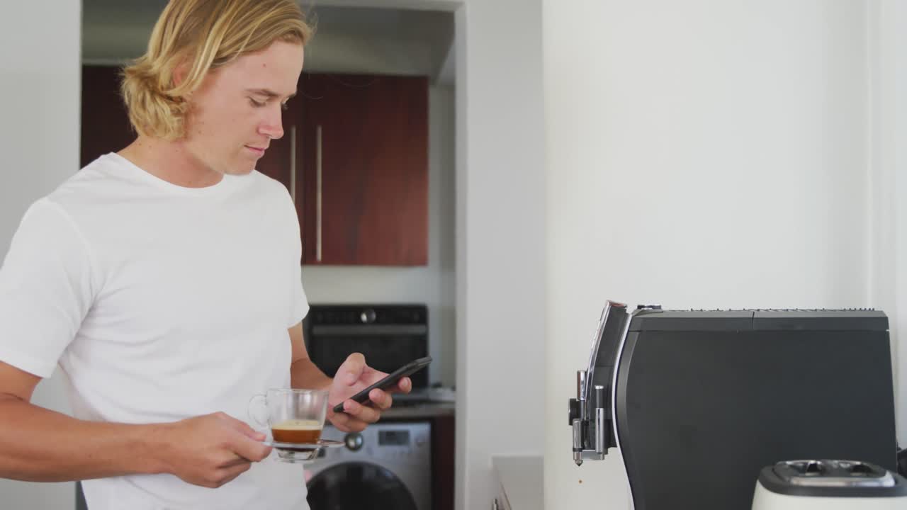 hombre sosteniendo taza de café mientras usa un teléfono inteligente