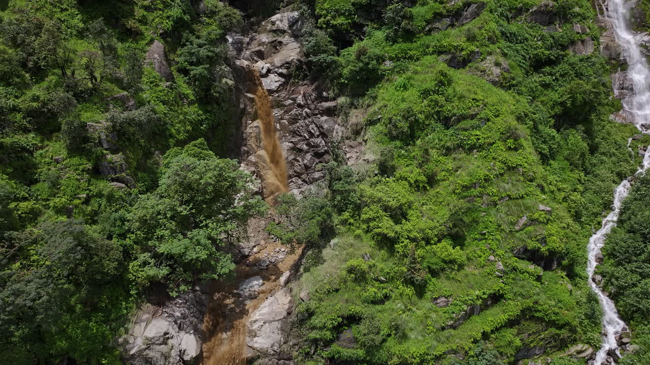 Drone shot captures Nepal’s waterfall and river flooding amidst the dense forests of Sindhupalchowk Muddy water landslides flows violently urgency of environmental protection and nature's wrath
