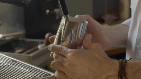 barista steaming milk for espresso drink