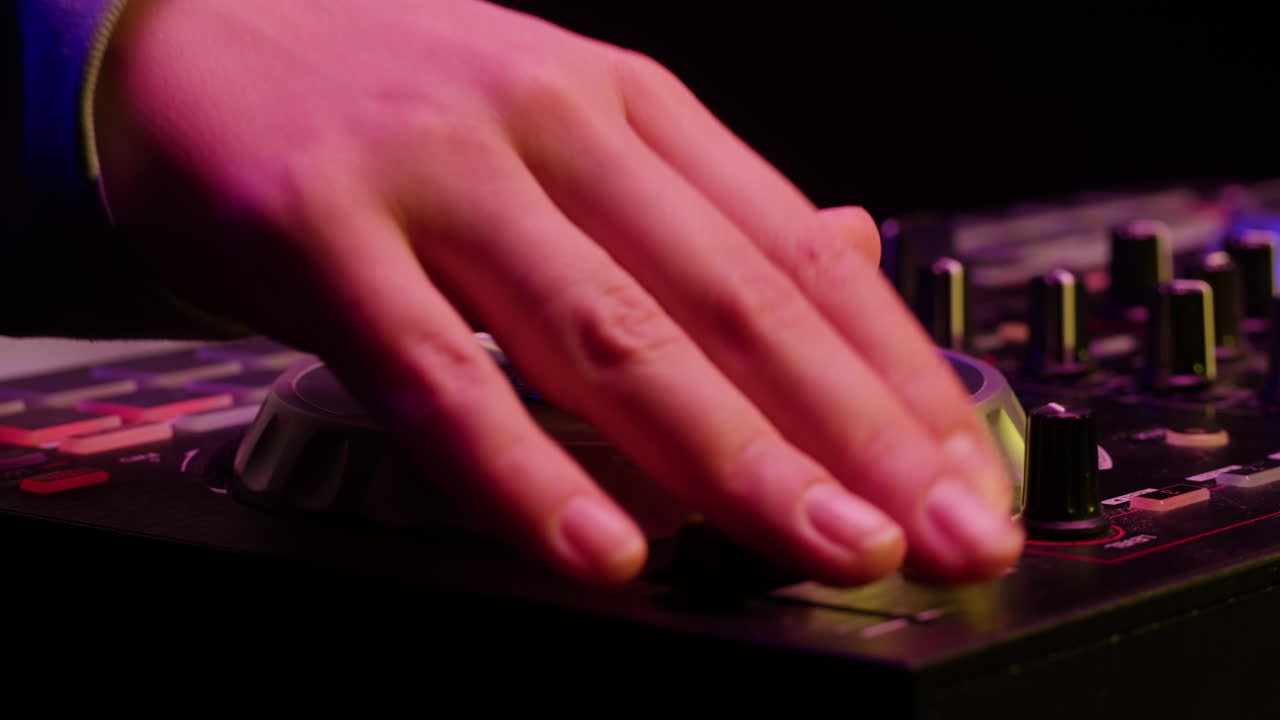 DJ with headphones and sunglasses playing music on festival in night club. Techno musician performing at nightclub for concert crowd of people, city bar.