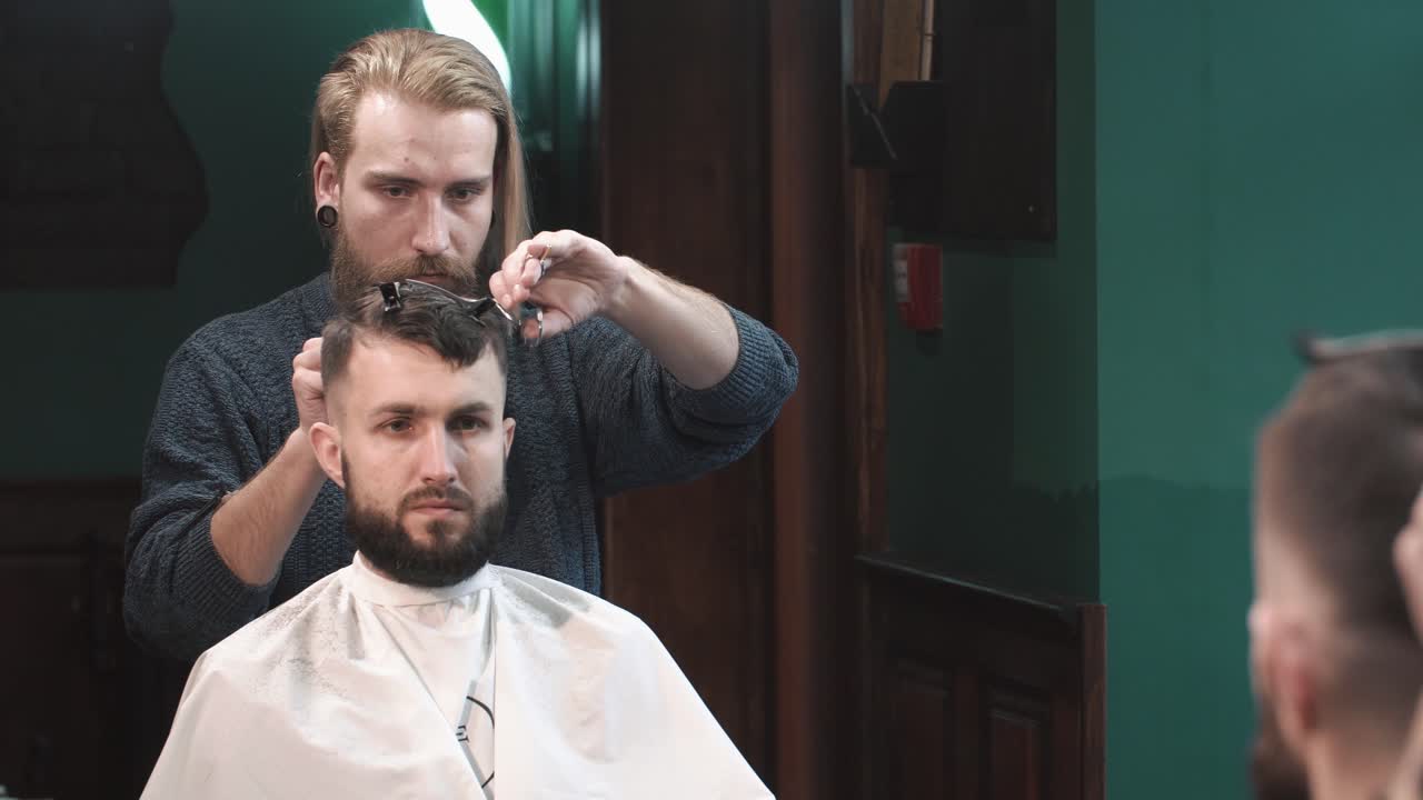 Barber klipper en mands hår i en barbersalon
