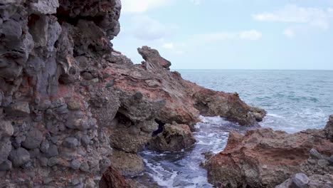 volcanic rocky cliffs hit by sea waves,serra d’irta natural park,spain