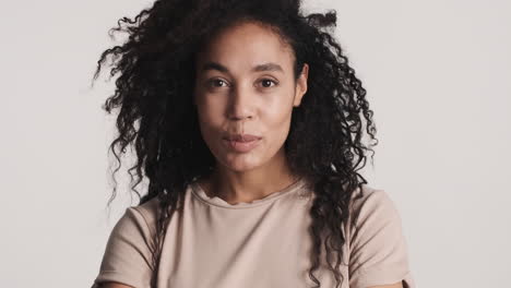 una mujer afroamericana segura de sí misma sobre un fondo blanco.