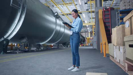 mujer inspeccionando equipos en una fábrica