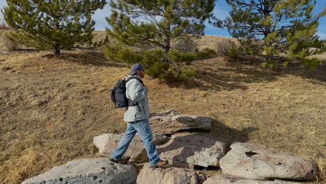 caucasian man with backpack hiking stops to enjoy the view in colorado