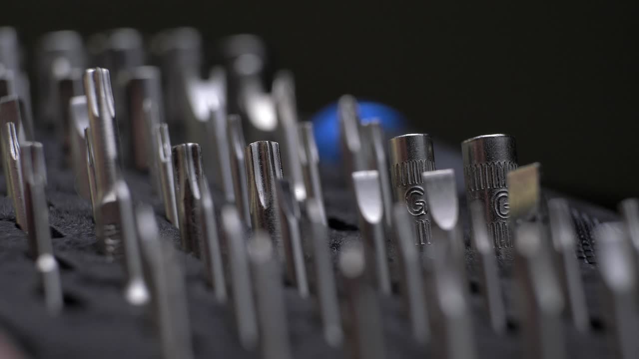 worker's hand pick from versatile steel Screwdriver kit, close up