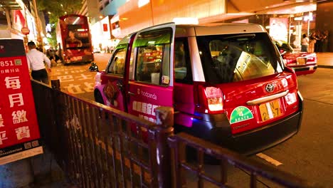 un taxi recogiendo pasajeros en una concurrida calle de hong kong.