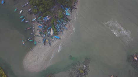 barcos tradicionales de madera con aguas onduladas en la playa de arena de palolem, isla de canacona, goa del sur, india