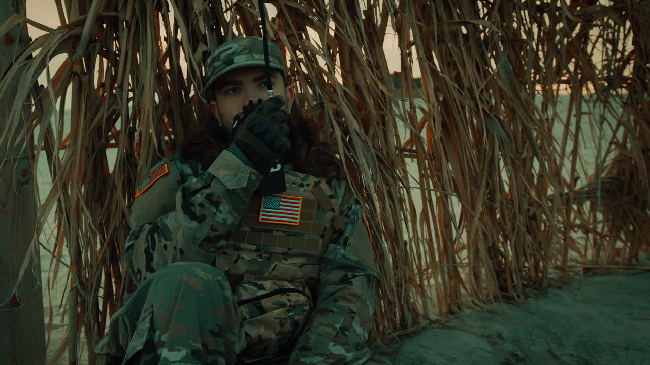 Soldato americano che parla alla radio in una base nel deserto e sorride felice per la vittoria