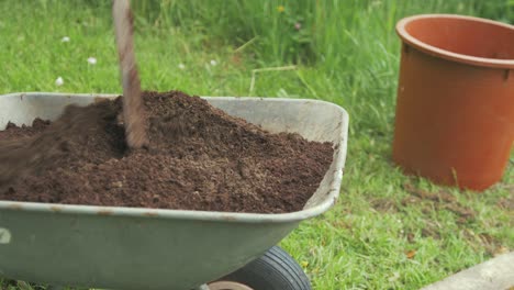 mixing soil in wheelbarrow with shovel gardening