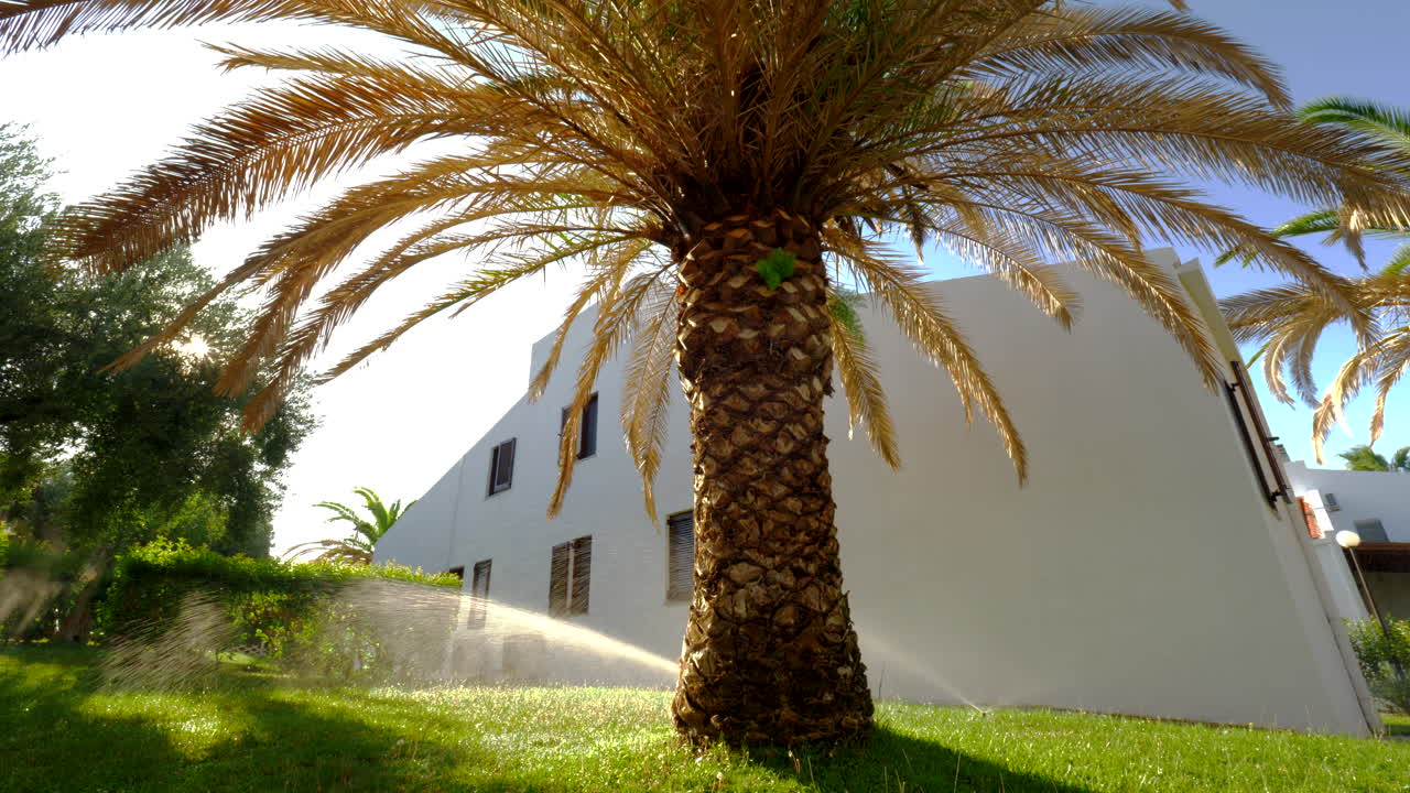 Casa de verão e aspersor automático regando o jardim