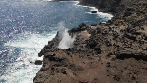 nakalele blowhole, maui, shiny ocean water burst from volcanic rocks aerial view