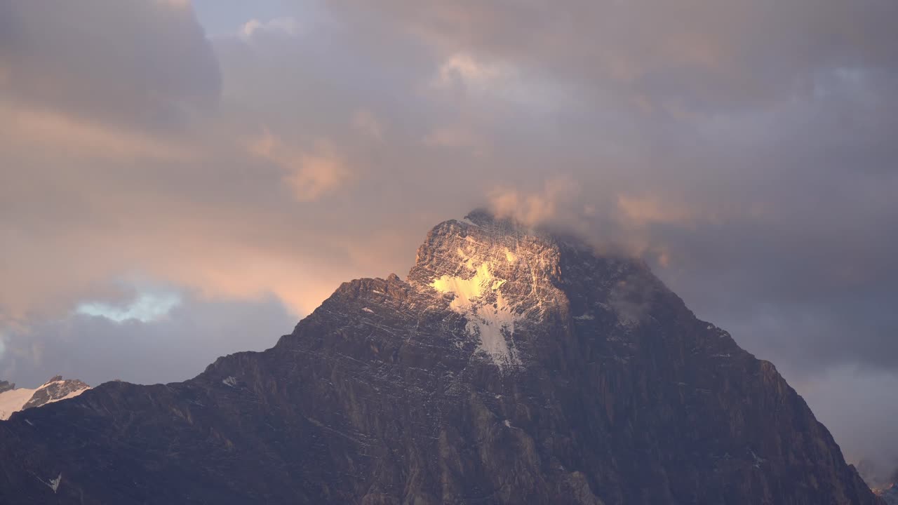 Golden morning light strikes the snow-covered summit of the Mittelhorn, highlighting its rugged texture and serene beauty in the Bernese Alps. Location: Bernese Alps, Switzerland (Schweiz).
