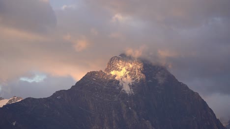 golden morning light strikes the snow-covered summit of the mittelhorn, highlighting its rugged texture and serene beauty in the bernese alps. location: bernese alps, switzerland (schweiz).