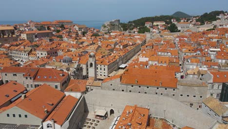 Aerial-drone-forwarding-shot-of-the-Old-City-of-Dubrovnik,-Croatia-with-old-residential-buildings-along-the-seaside-on-a-bright-sunny-day