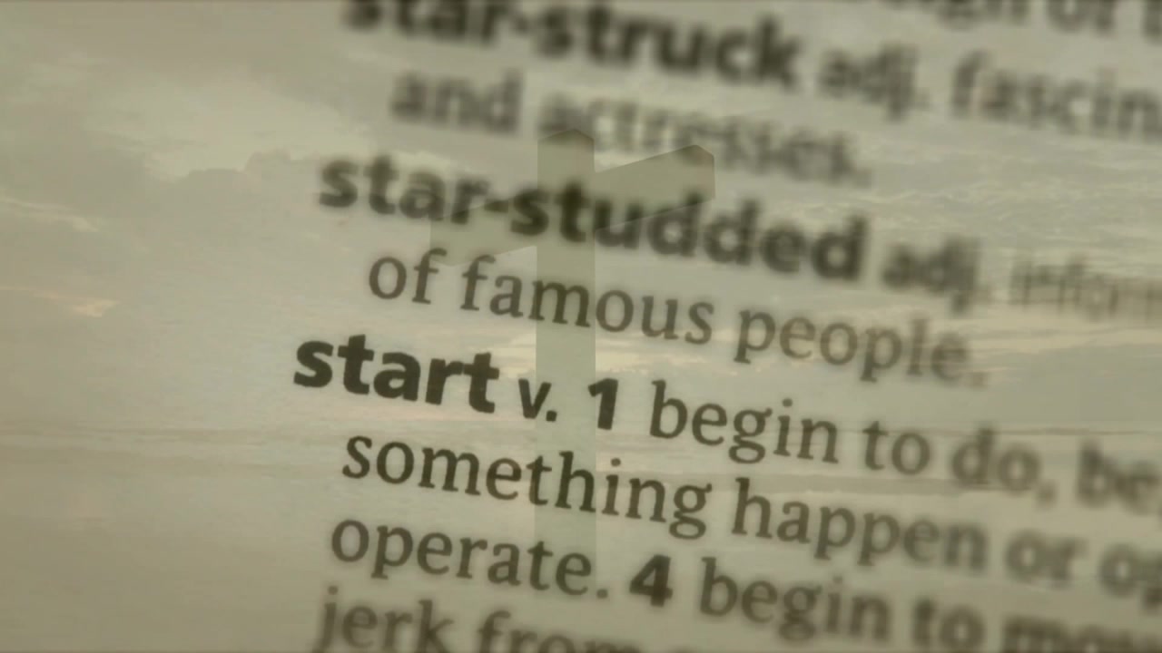 Lens pulling focus from blur, sharpening dictionary and emphasizing headword start with signpost
