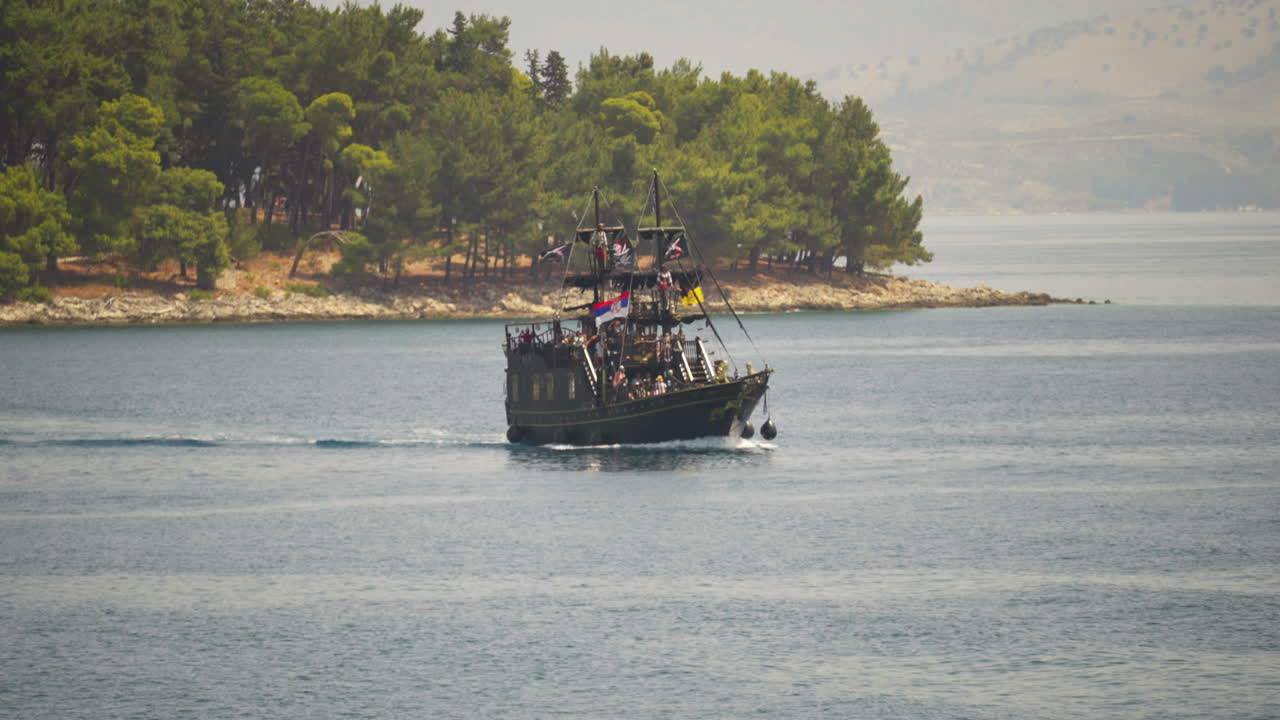 Slow-motion 4k footage of pirate ship sails towards the camera in a bay near Corfu island.